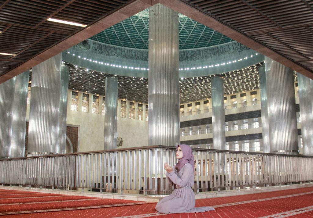 A Muslim woman in prayer inside the Istiqlal Mosque, Jakarta, Indonesia.