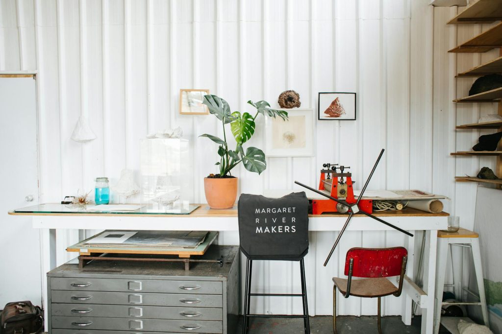 Artistic studio featuring a vintage printing press, decor elements and plants.