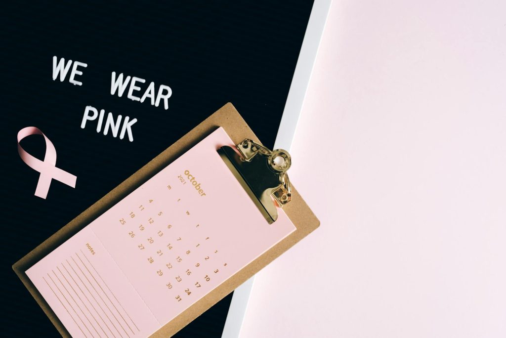 Pink calendar on clipboard with ribbon for breast cancer awareness and copy space.