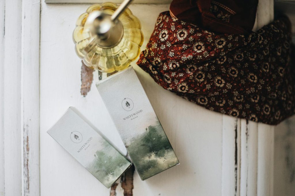 Chic composition of skincare products with a decorative scarf, evoking luxury and warmth.