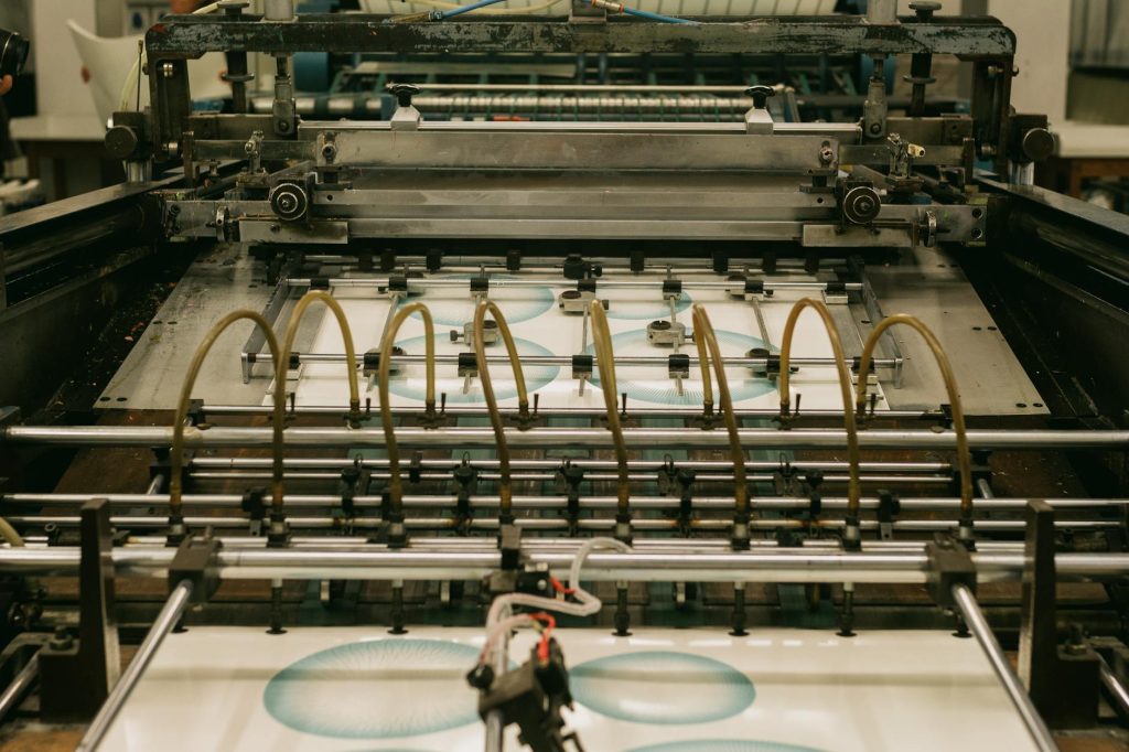 Close-up of an industrial printing press producing designs.