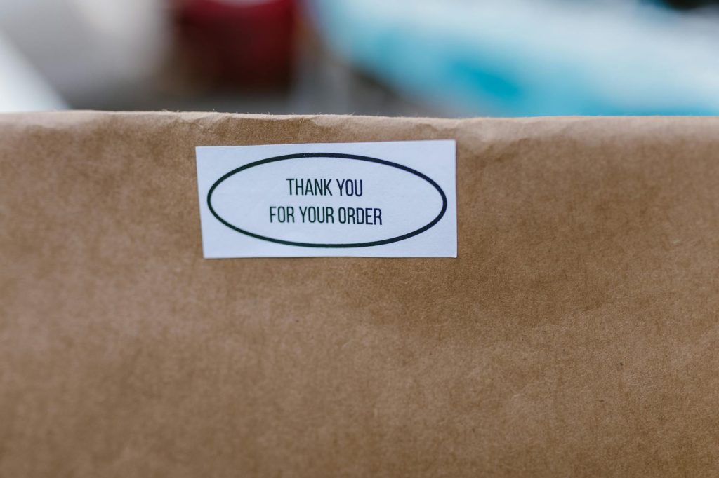 Brown paper bag with a thank you sticker, ideal for delivery concepts.