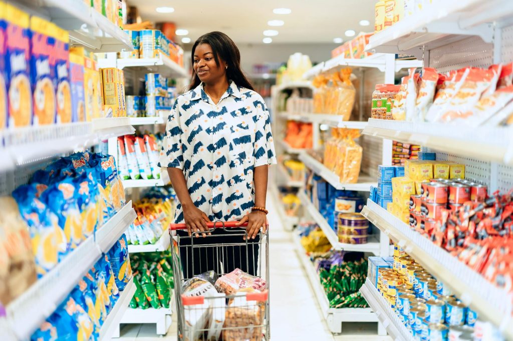 A woman enjoying grocery shopping in a vibrant Lagos supermarket aisle.