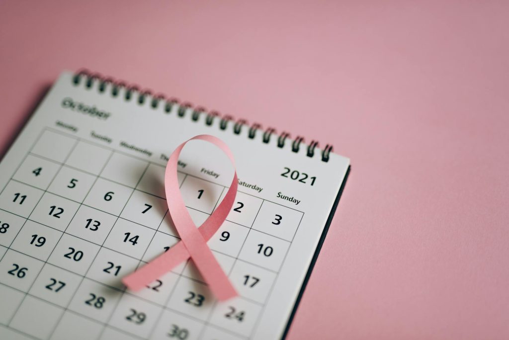 Pink ribbon on an October calendar for breast cancer awareness.