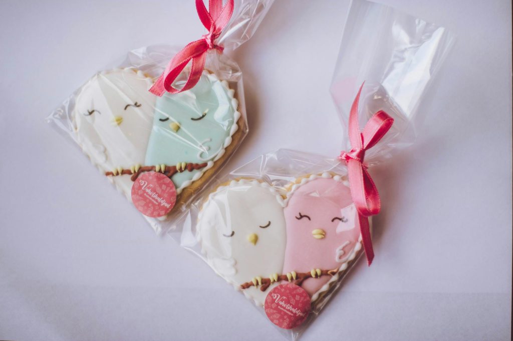 Charming heart-shaped cookies with bird designs, perfect for Valentine's gifts. Wrapped with ribbons.