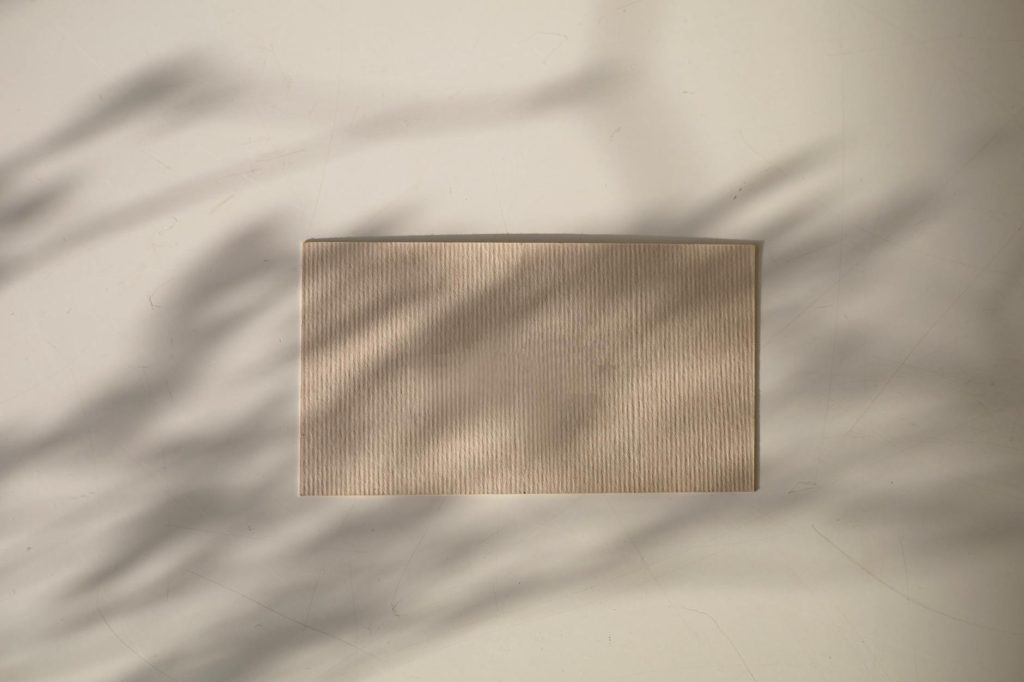 Textured blank card placed on a light surface with soft shadows, ideal for design mockups.