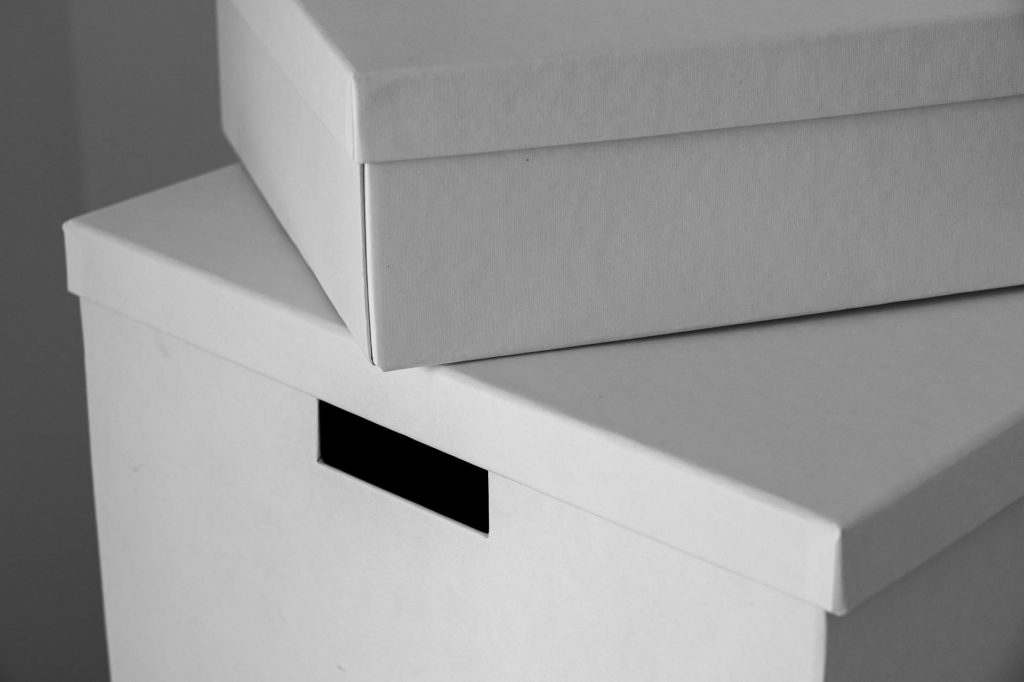 Close-up of minimalist white cardboard boxes stacked with ample copy space. Ideal for design or storage themes.
