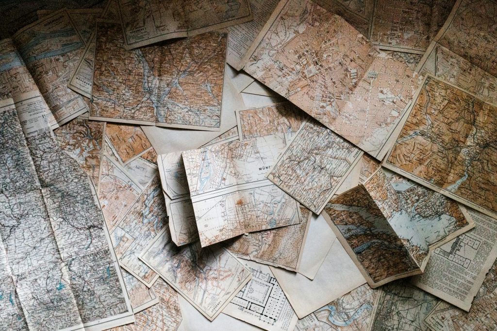 A collection of vintage maps scattered for exploring world journeys and discoveries.