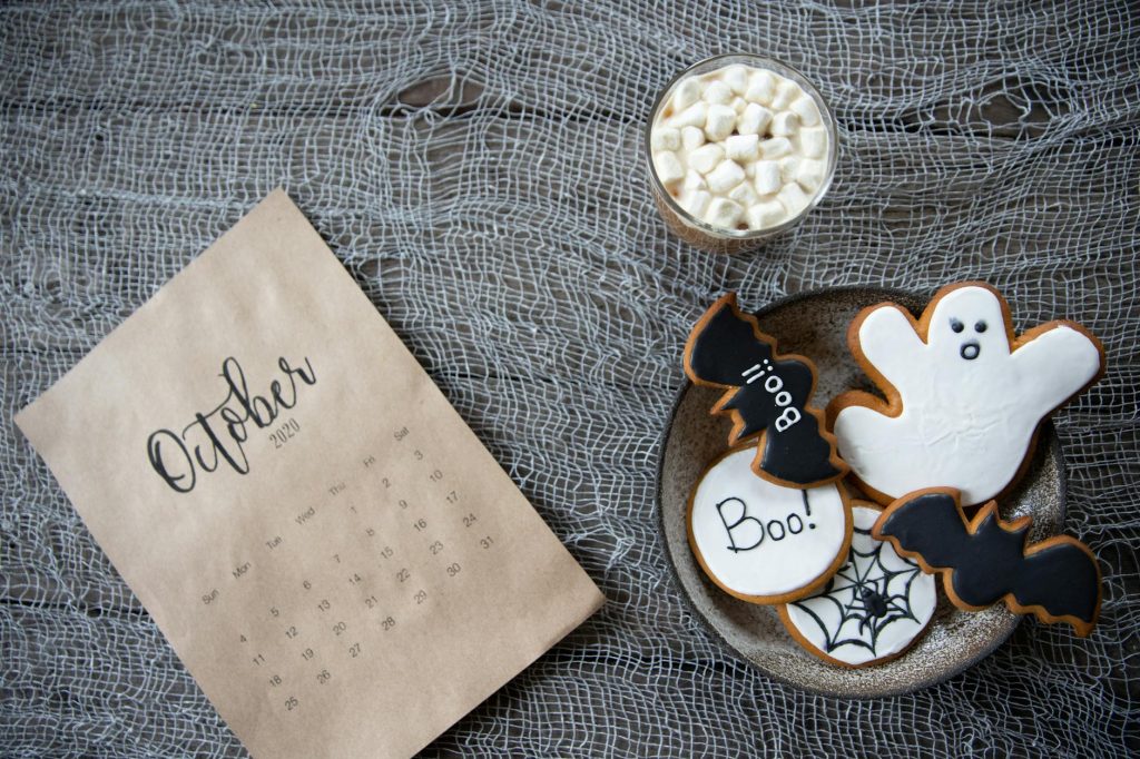 Halloween themed cookies and October calendar on a rustic background, perfect for festive holiday design