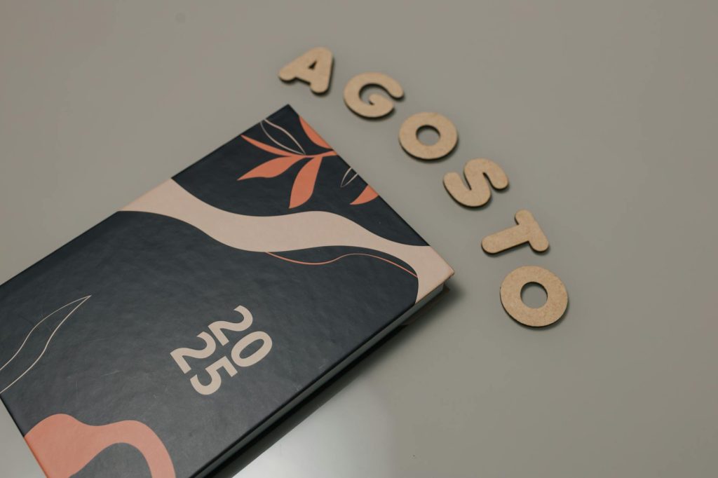 Artistic 2025 planner with decorative elements and 'Agosto' letters, perfect for creatives.