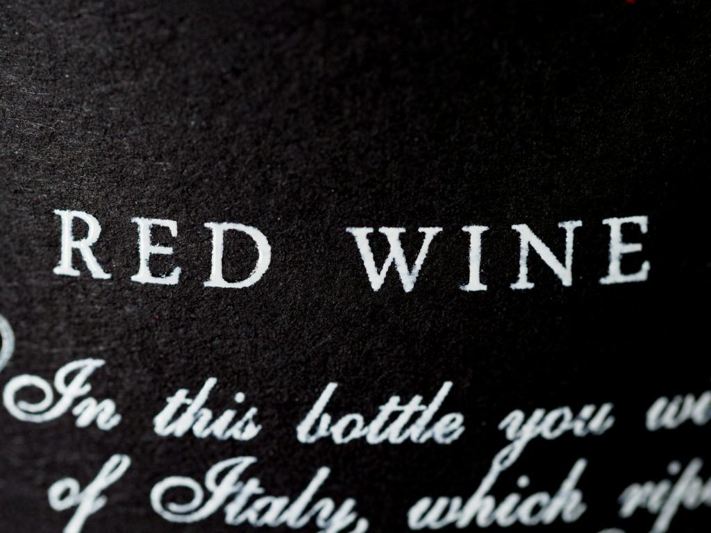 Macro photo of a red wine bottle label with elegant typography.