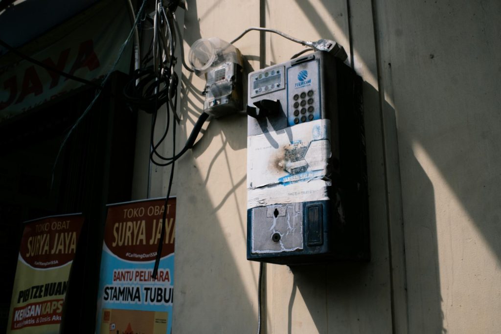 Retro payphone on Jakarta street, capturing urban nostalgia and vintage technology.