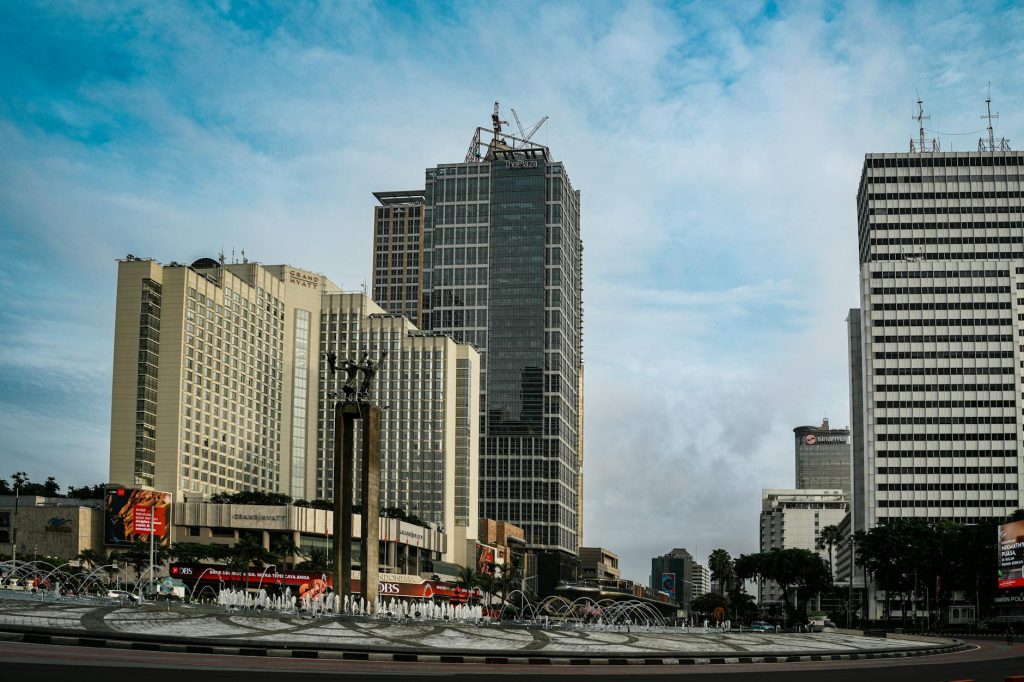 High-rise buildings and fountain at Bundaran HI, Jakarta during daytime.