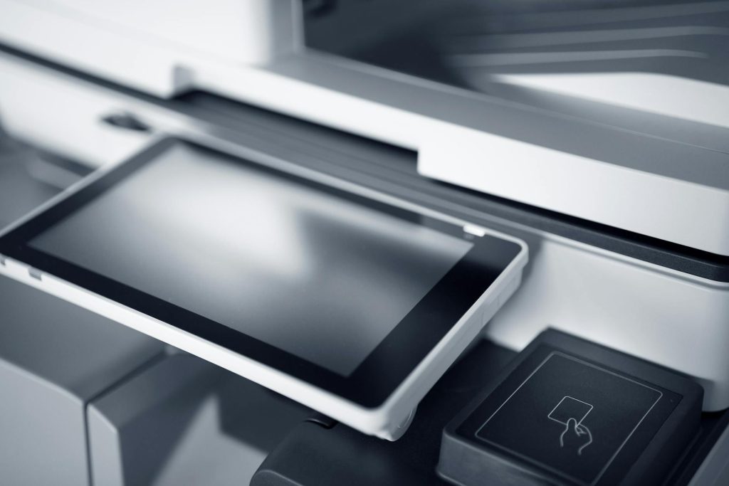 Close-up of a modern printer with a touchscreen interface in a professional office setting.