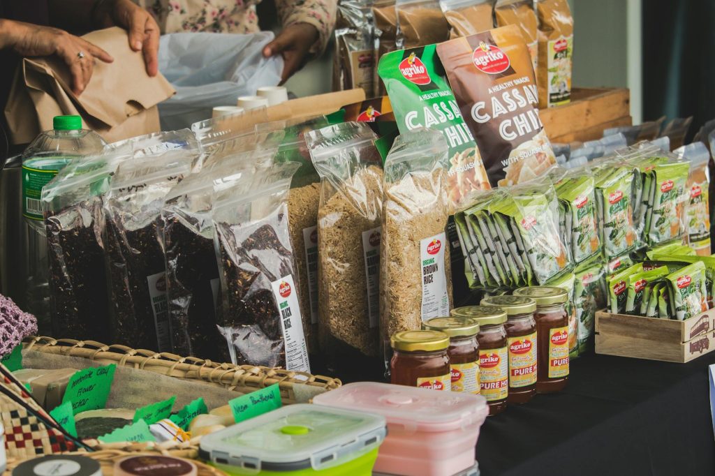 An assortment of packaged foods displayed on a market stall indoors, showcasing variety.