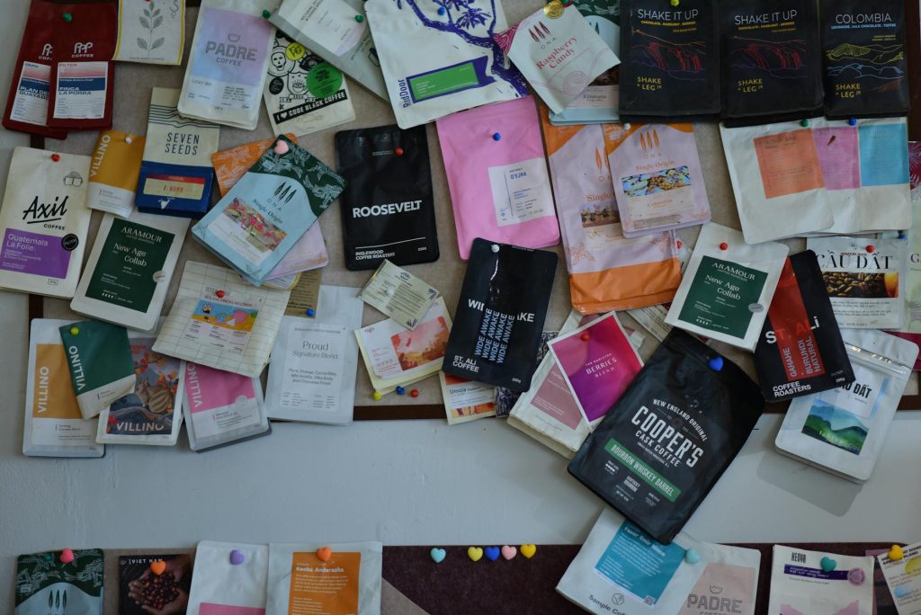A vibrant collection of diverse coffee packaging displayed on a wall, highlighting design variety.