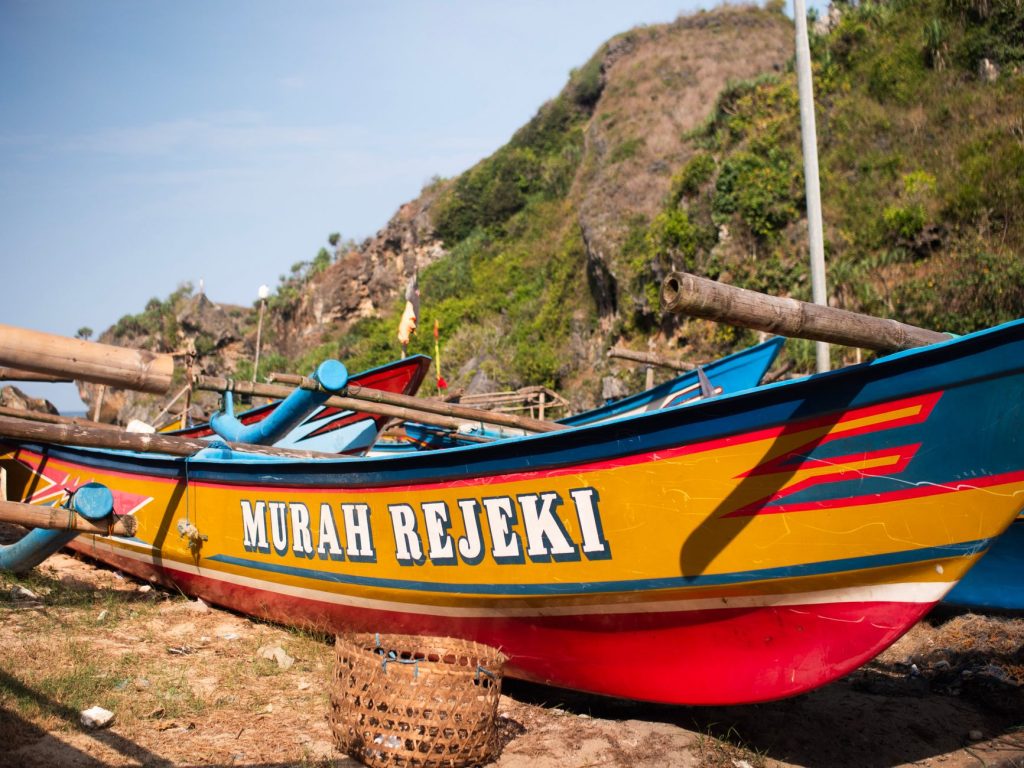Vibrant fishing boats with tropical backdrop in a coastal setting, showcasing local culture.