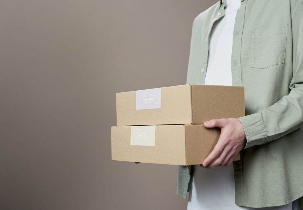 Close-up of a person holding thank you labeled boxes, ideal for delivery themes.
