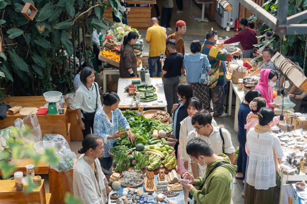 Indoor market scene bustling with diverse shoppers exploring fresh produce and goods.