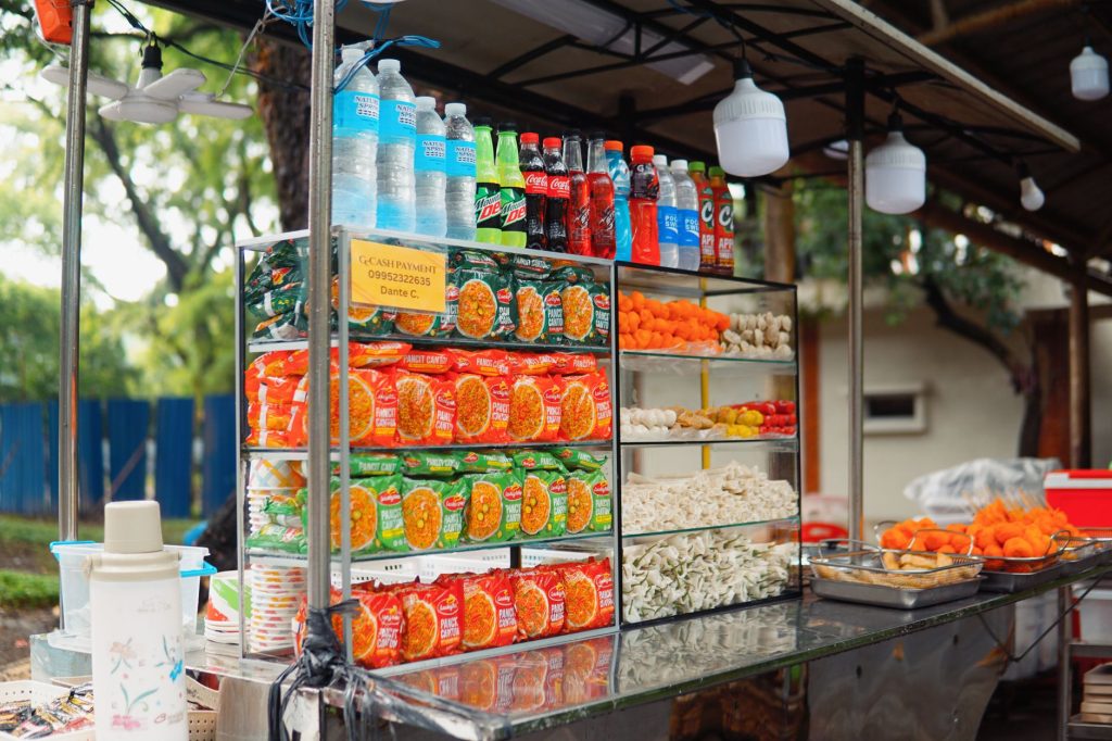 Colorful street food stall with snacks and beverages neatly arranged, offering a local flavor.