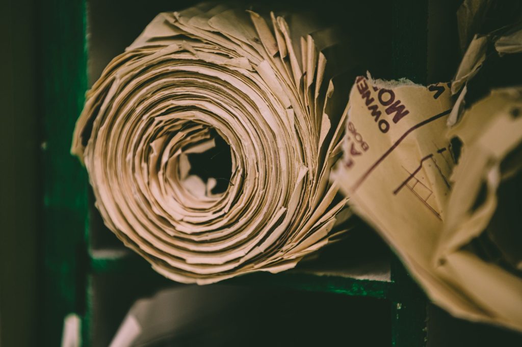 Closeup of roll of craft eco friendly paper bags placed on shabby shelf at factory